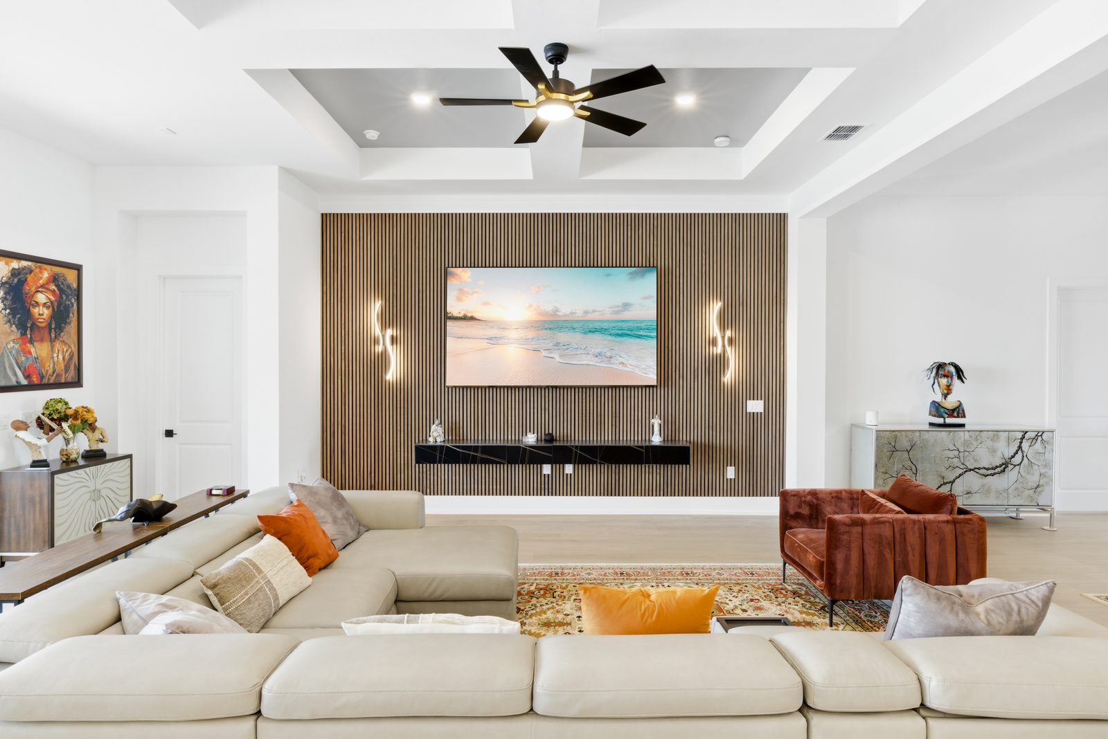 Living room with a wall-mounted TV set into a floor-to-ceiling natural wood slat wall, a floating console, LED wall sconces and a sectional sofa
